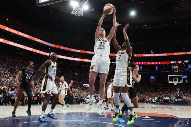 Indiana Fever’s Caitlin Clark (22) grabs a rebound beside teammate...