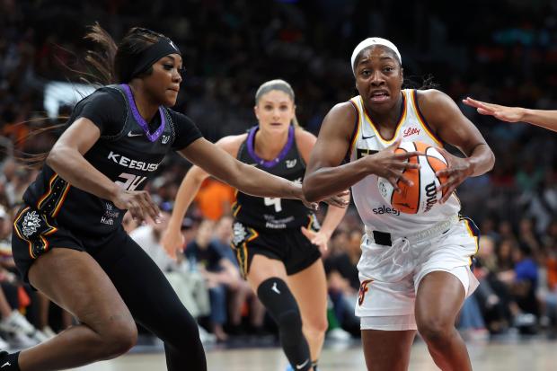 Indiana Fever’s Aari McDonald drives past Connecticut Sun’s Aneesah Morrow...