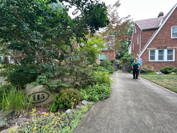 John and MaryAnn Thesing stand in their front driveway. Their house is part of the upcoming Euclid Pond and Garden Tour. (Frank Mecham- The News-Herald)