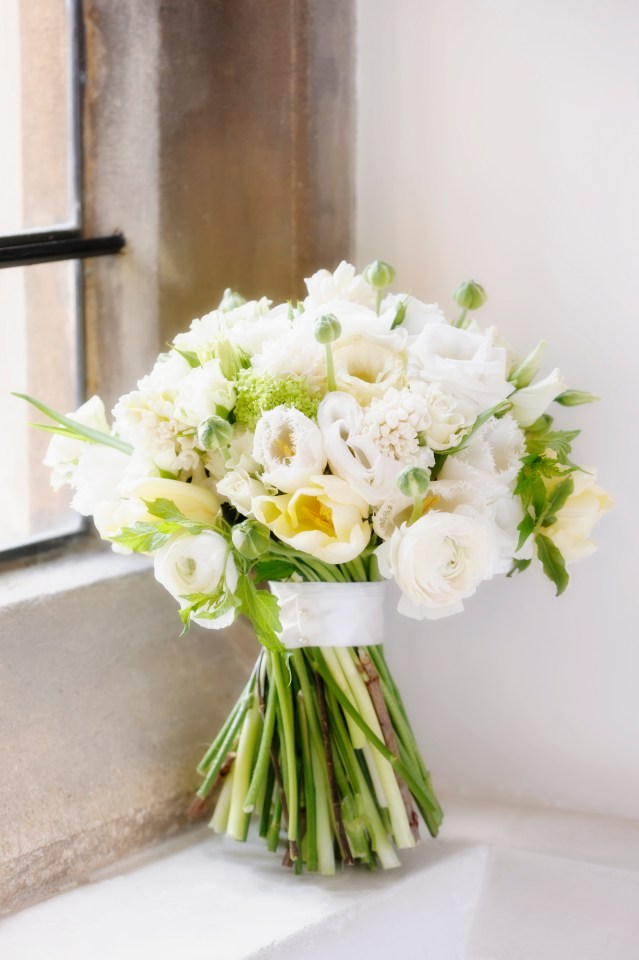 Wedding bouquet of white and pale yellow flowers on a windowsill.