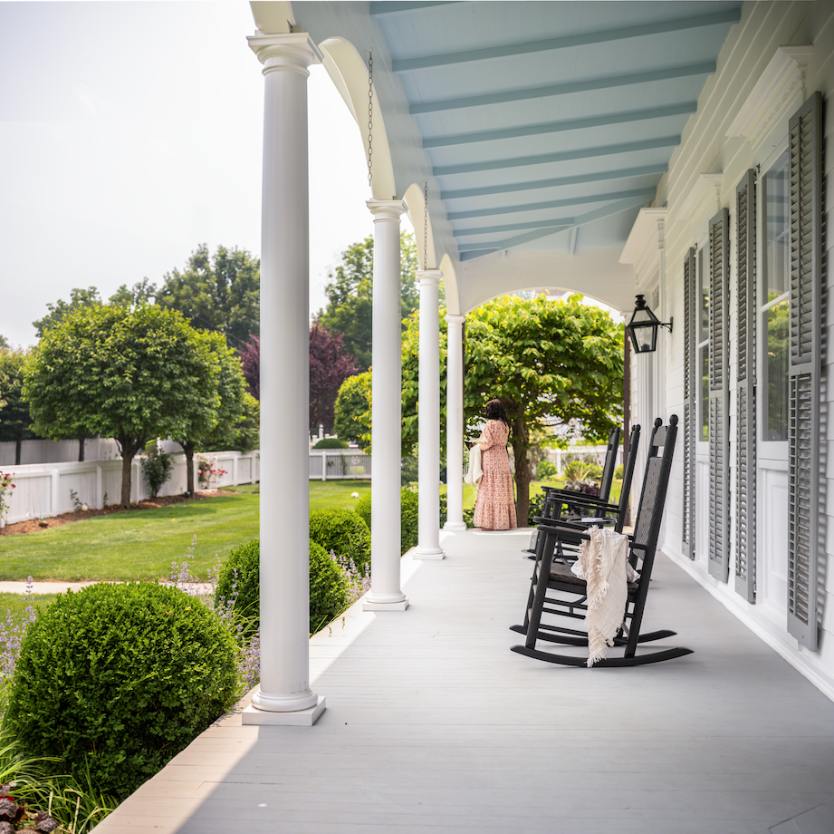 porch with blue ceiling and rocking chairs looking out onto yard