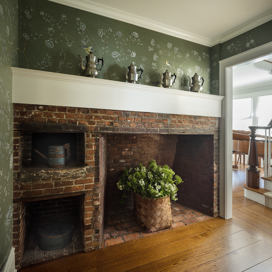 vestibule with floral wallpaper and old fireplace