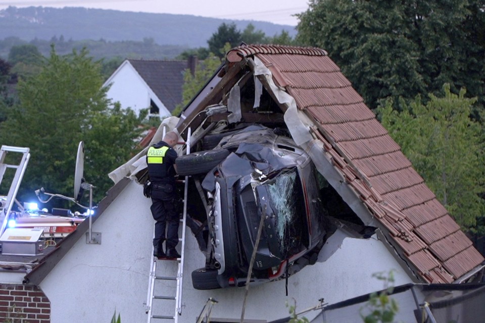 Police officer investigating a car crashed into a house.