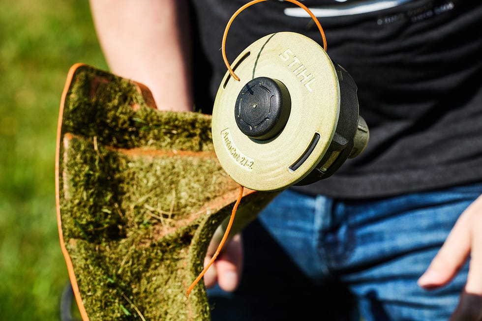 string trimmer head with grass clippings