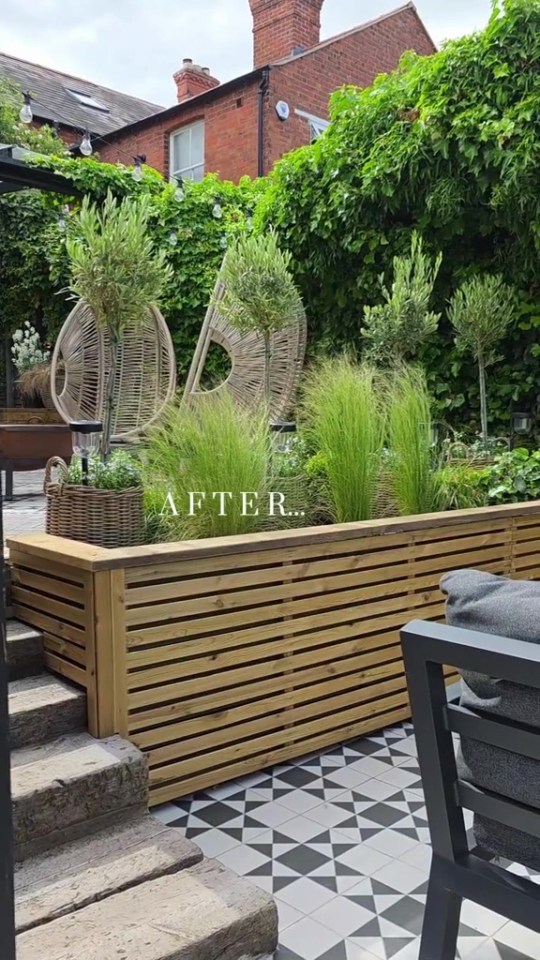After photo of a garden makeover with new plants, planters, and a wooden wall.