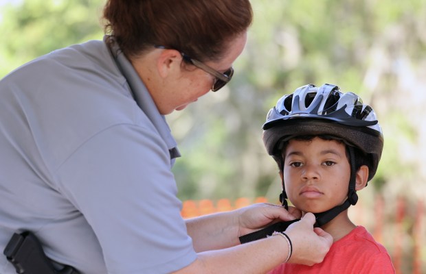 Winter Garden Police Officer Sarah Price helps Landon Wilson, 8,...