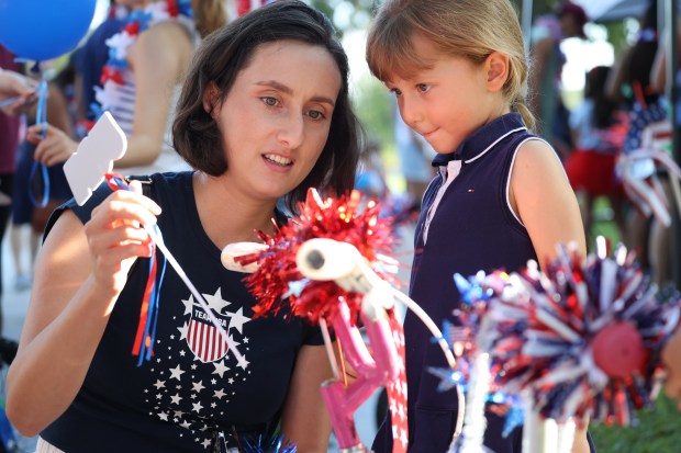 Mom Jana Melo helps Amanda, 4, with decorating her bicycle...