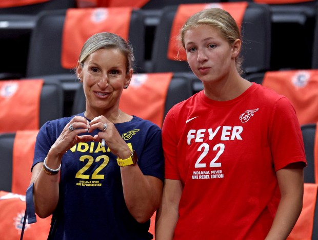 A fan flashes the “heart” sign as Caitlin Clark warms...