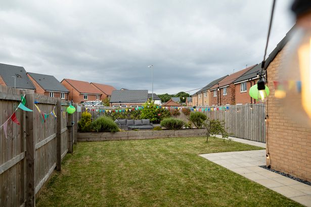 Long shot of a garden in the North East of England set up for a party. There are glands and bunting hanging around.