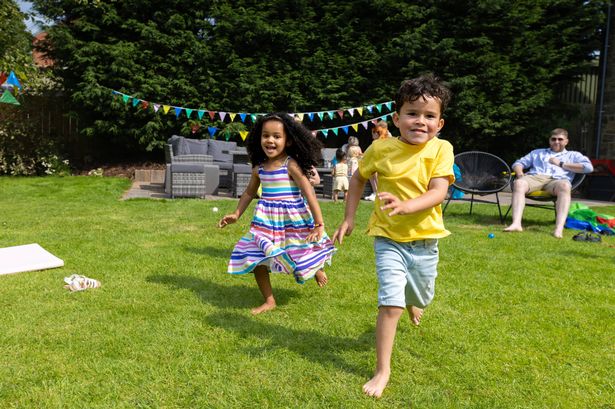 Full shot of two children running through a garden with friends and family watching them in the background. They are both dressed in summer clothing. Located in Northumberland, England.

Video for this scenario is available