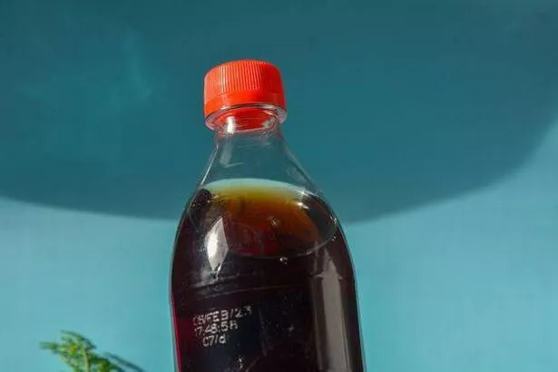 a black drink with a red cap and a transparent bottle.