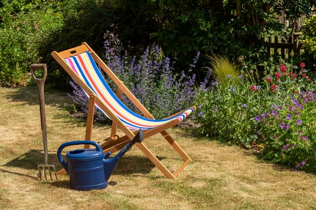 An open colorful deckchair in an English country garden.