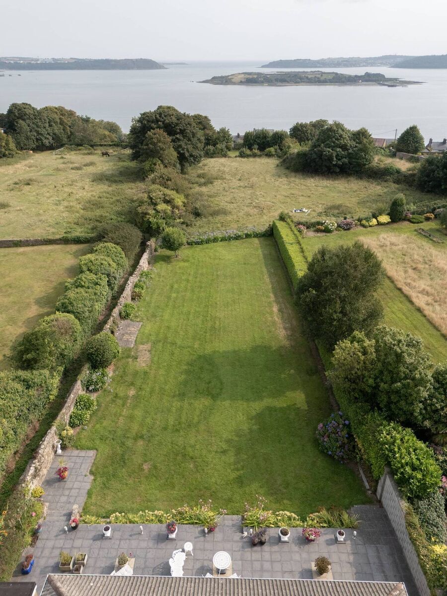 The land drops away at the bottom of the garden so that the house seems closer to the water when viewed from the patio