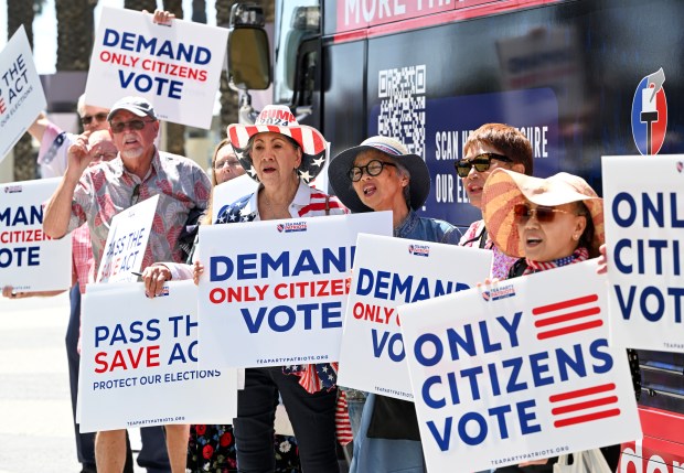 Imelda Preciado, of Garden Grove, center, joins other supporters of...