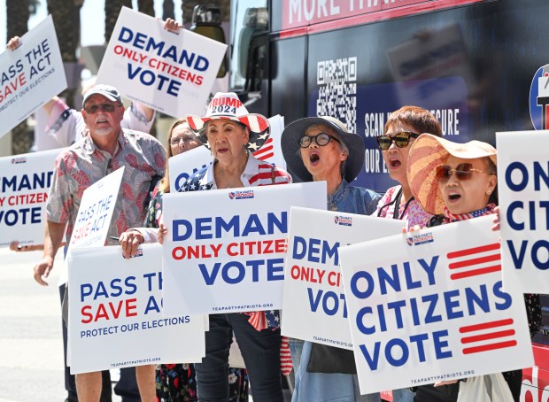 Imelda Preciado, of Garden Grove, center, joins other supporters of...