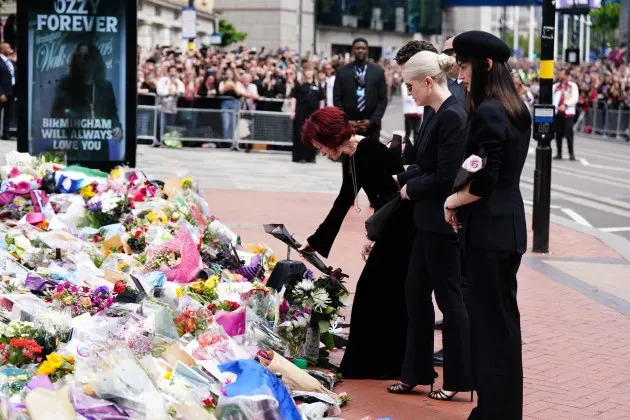 Sharon Osbourne, with family members, lays flowers at the Black Sabbath Bridge bench on Broad Street in Birmingham in memory of Black Sabbath frontman Ozzy Osbourne on July 30, 2025 - Credit: Jacob King/PA Images via Getty Images