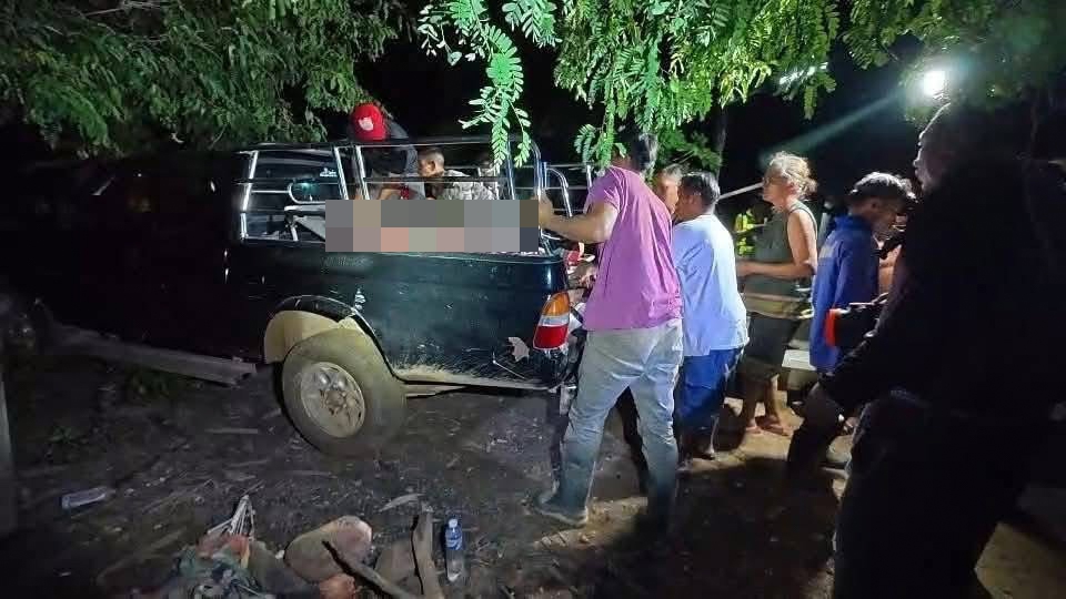 Villagers load an injured person and a deceased person into a truck after an elephant attack.
