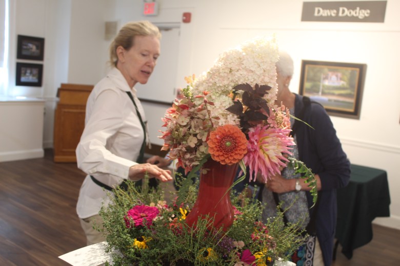 Monadnock Garden Club President Robin Turnbaugh shows off her floral arrangement piece. ASHLEY SAARI/Ledger-Transcript