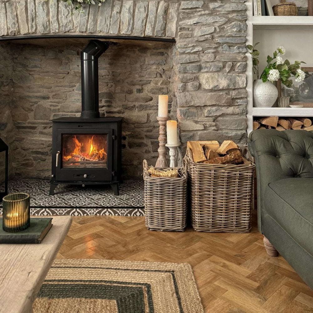 Wood burning stove with firewood baskets in a living room.