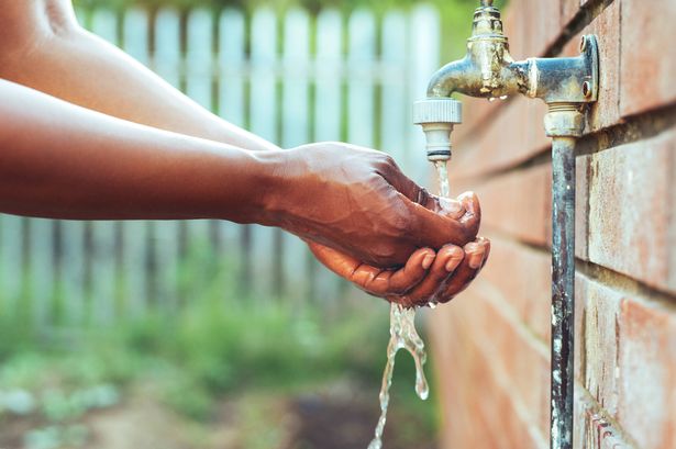 Cropped shot of an unrecognizable woman washing her hands outdoors