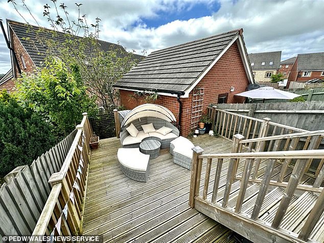 The grand decking with flags and curved patio sofa was a feature of the house on the estate agent site - and she assumed it had been there since the modern estate was built 20 years ago