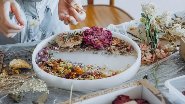 Woman arranging dried flowers in a mold