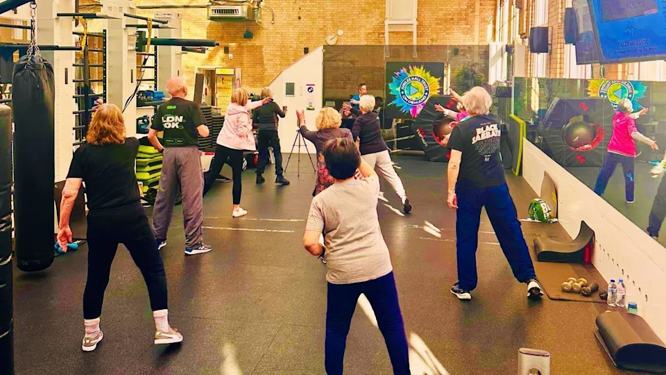 People taking part in an exercise class inside the gym.