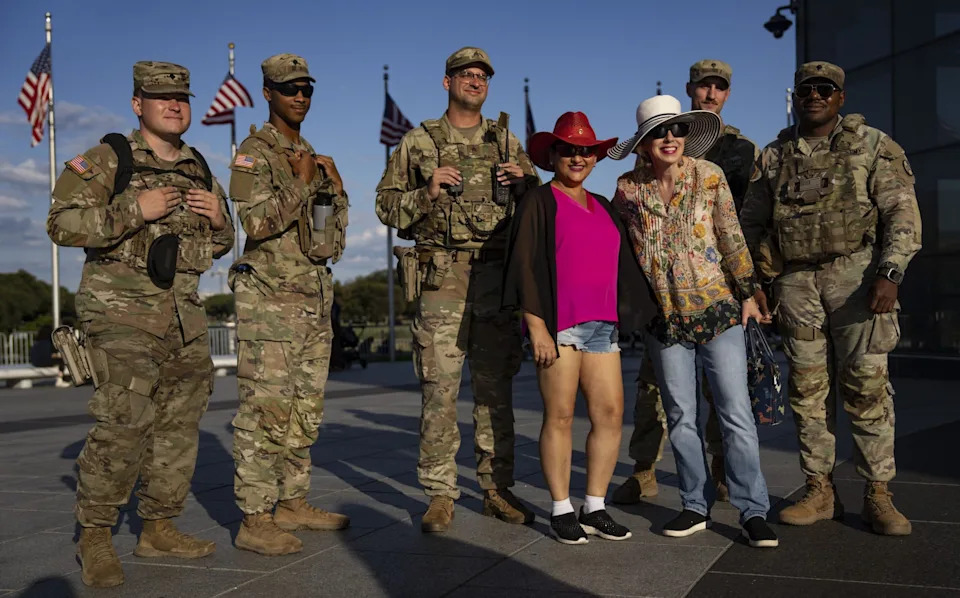 Members of the National Guard pose for photos with tourists neat the Washington Monument