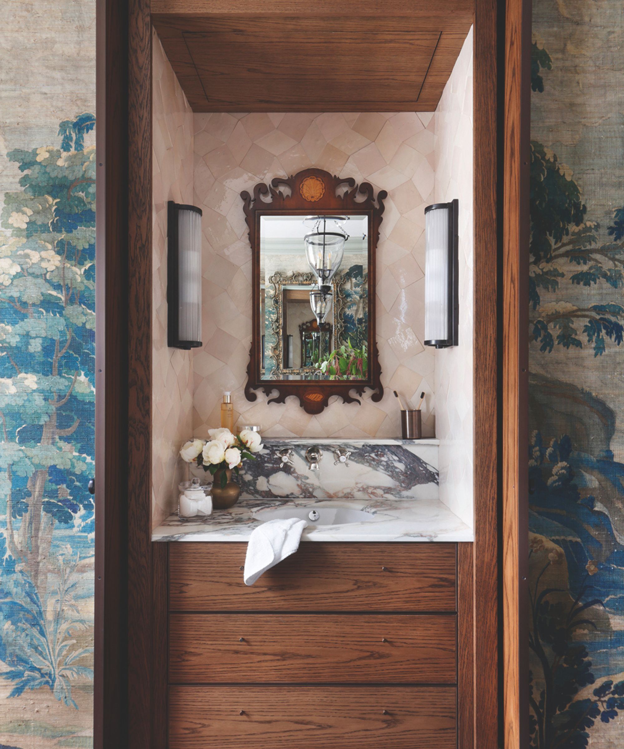 A marbles vanity unit with wooden drawers and luxurious soft pink tiles