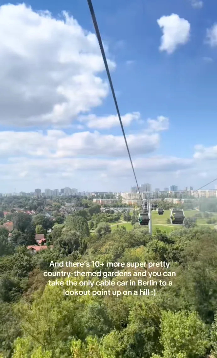 View of Berlin from a cable car with text about more country-themed gardens and the city's only cable car leading to a hilltop lookout point