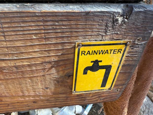 A rainwater sign is displayed on an outdoor sink at the home of harvesting expert Brad Lancaster in Tucson, Ariz., on Aug. 1, 2025. (Anita Snow via AP)