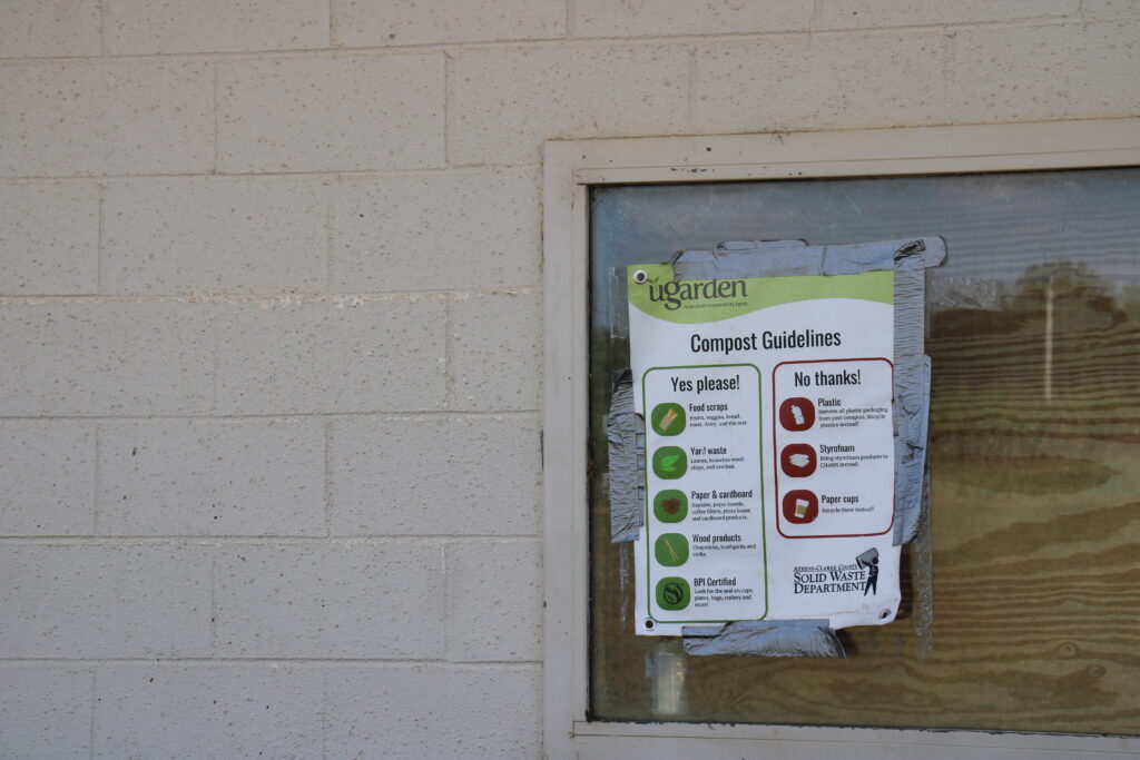 A compost poster showing how to compost is taped onto a window on UGArden's property.