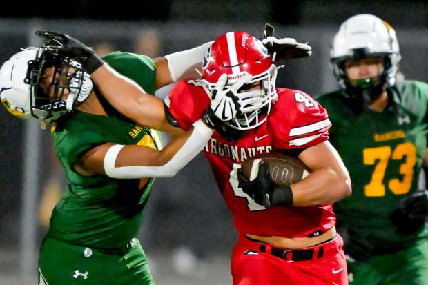 Quentin Pacelli (4) of Garden Grove stiff-arms Erick Najera (21)...