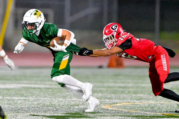 Davian Sanchez (5) of Rancho Alamitos gets pulled down by...