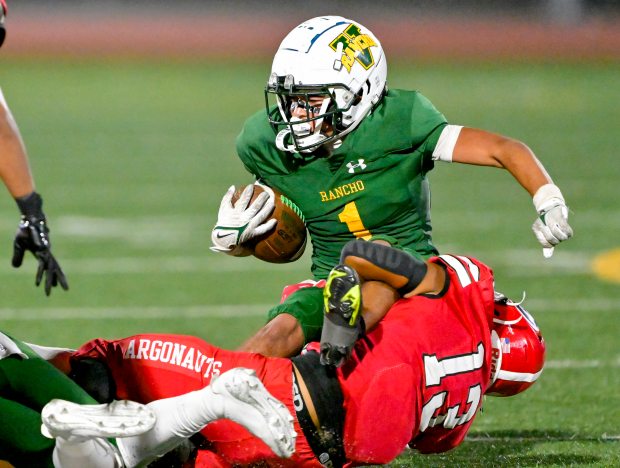 Joe Vazquez (1) of Rancho Alamitos is tackled by Carlos...