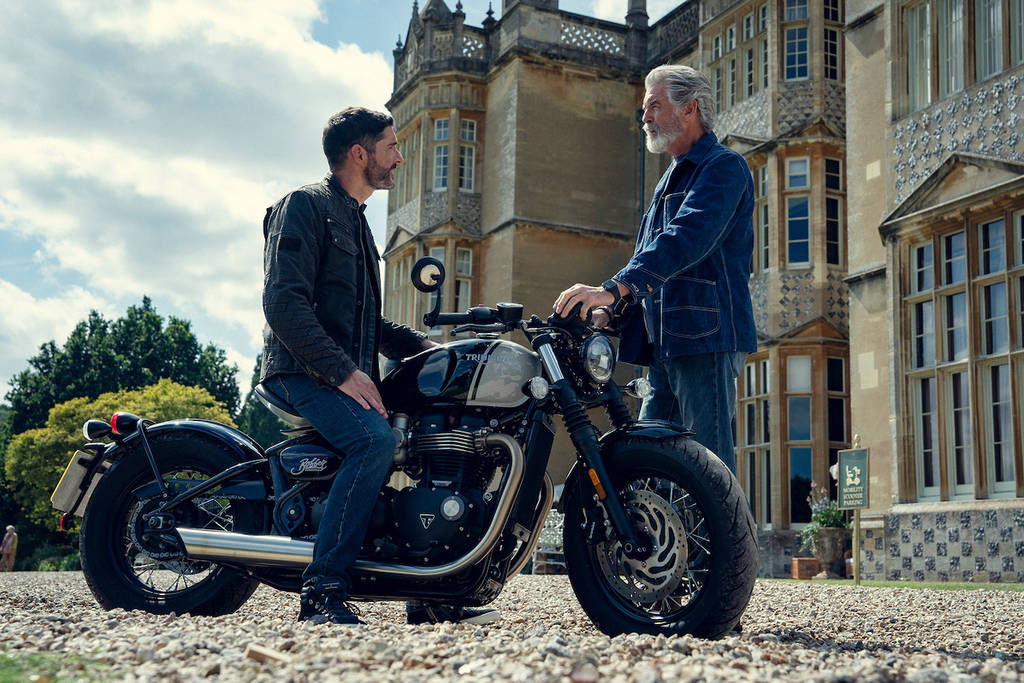 Tom Ellis on a motorbike talks to Pierce Brosnan in The Thursday Murder Club
