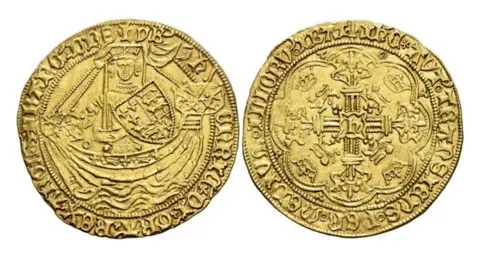 David Guest Numismatics Some of the coins from the collection. They are gold and have old English words written on them, along with engravings of a man wearing a crown and carrying a shield in what appears to be a boat on the left. On the right the engraving looks to be of a coat of arms. 