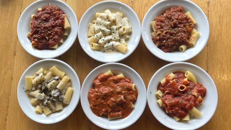 Six pasta sauces with pasta in bowls