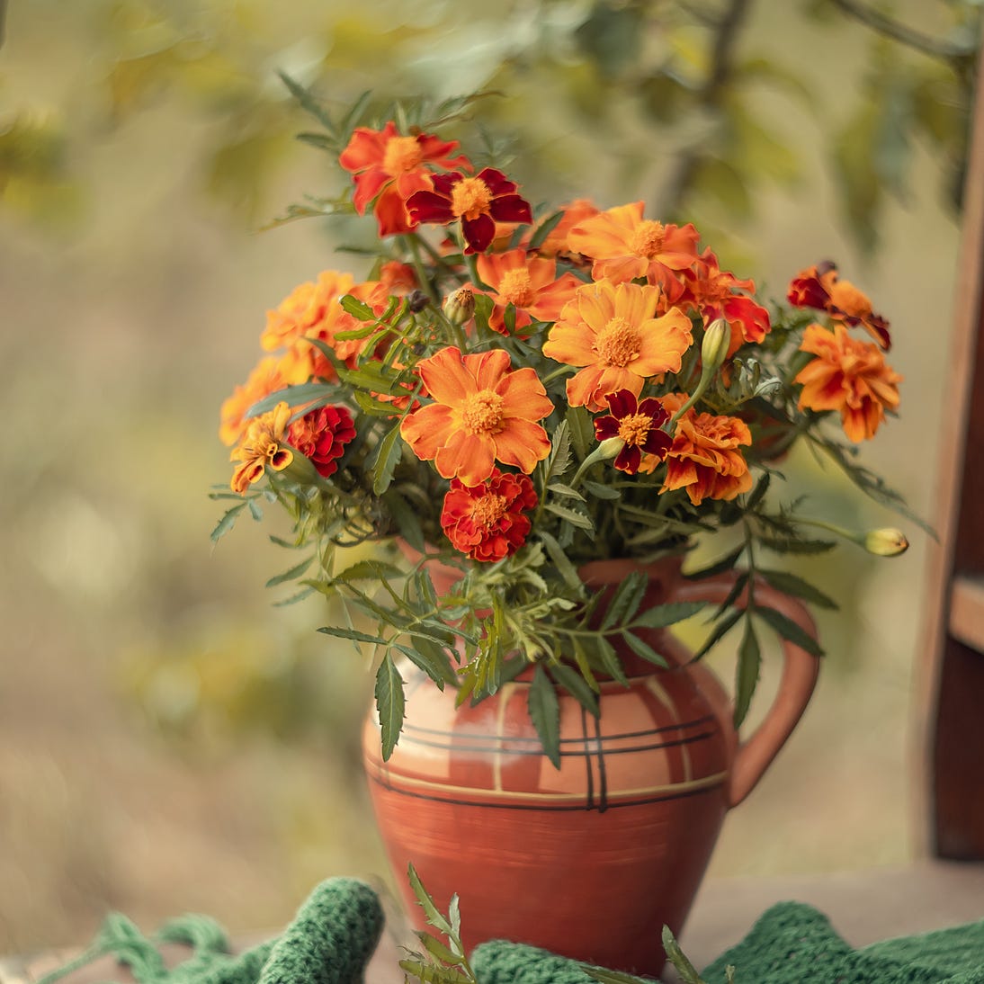 an arrangement of gold and orange marigold flowers in a vase