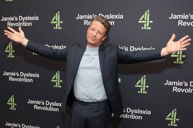 Jamie Oliver standing with his arms out wide