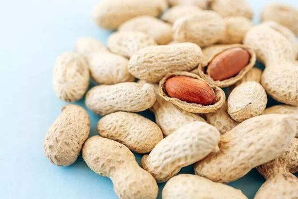 Pile of Peanuts with cracked two on blue background