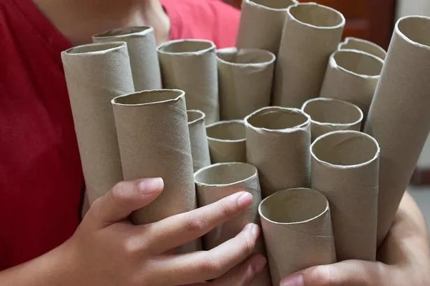 Girl holding the empty paper rolls.