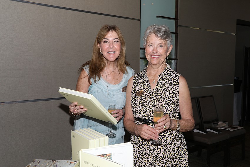 Cindy McCollum and Susan Gee admire the Rebecca Louise Law coffee table book for sale.