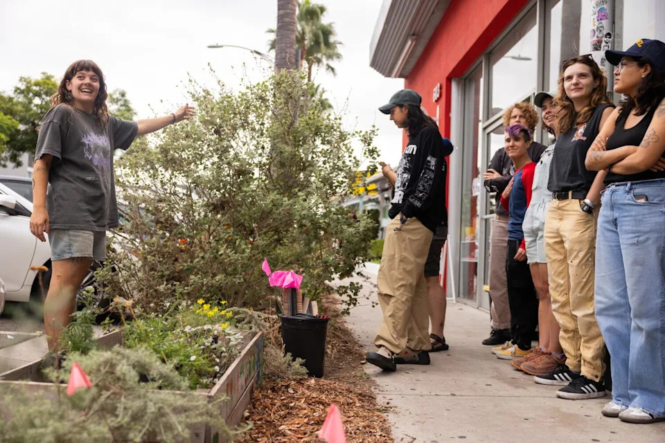 Club Gay Gardens co-founder Maggie Smart-McCabe gestures toward the parkway garden