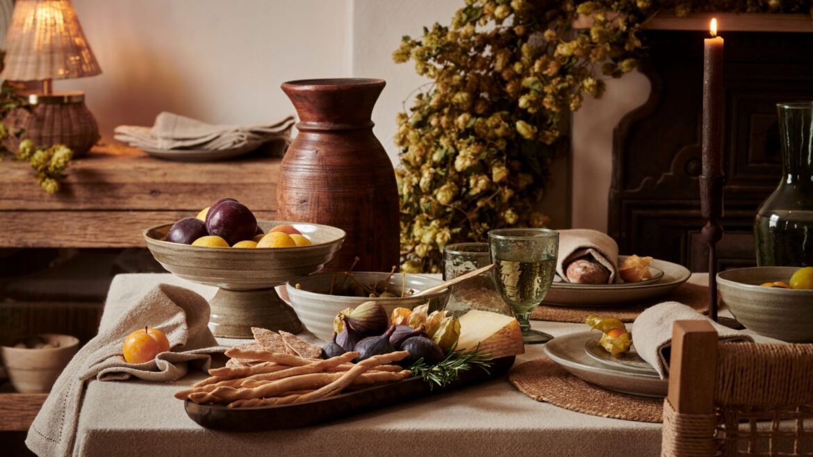 5 Ways to Store Fall Produce Without Using Plastic A fall dining table laden with seasonal food in stoneware dishes.