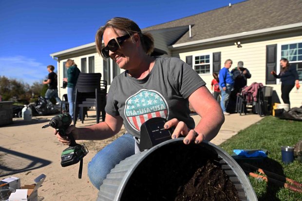 Diana Kelly of Blandon installs solar light as part of a home repair project in Kutztown for Keystone Family Alliance on Saturday, Oct. 25, 2025. (BILL UHRICH/READING EAGLE)