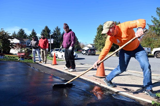 Chad Hendrickson of Exeter Township seals the driveway as part of a home repair project in Kutztown for Keystone Family Alliance on Saturday, Oct. 25, 2025. (BILL UHRICH/READING EAGLE)