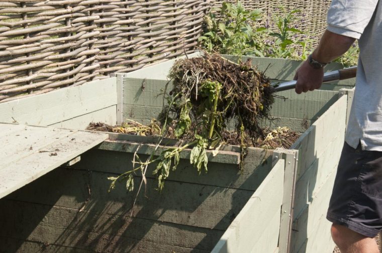 Turning a compost heap, by removing all the compost from the bin, mixing and replacing at RHS Garden Hyde Hall. Image via Guy Barter