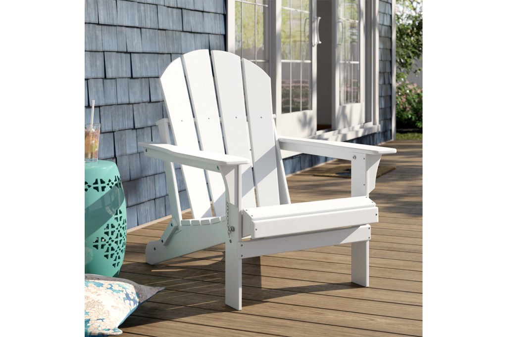 White Adirondack chair on a wooden deck.