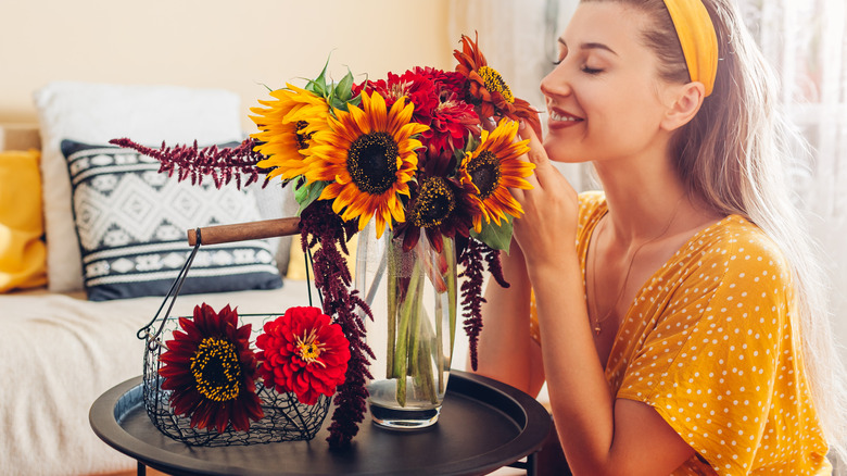 Woman arranging and smelling a fall-inspired bouquet